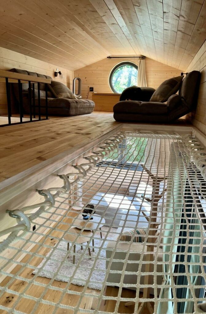 Intérieur chaleureux et lumineux de la Tiny House Astéria avec coin salon cosy et décoration esprit nature