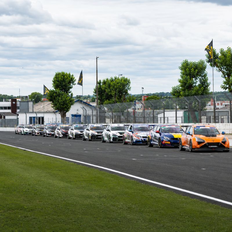 Voitures de course alignées sur la grille de départ du Circuit d’Albi avant un événement automobile